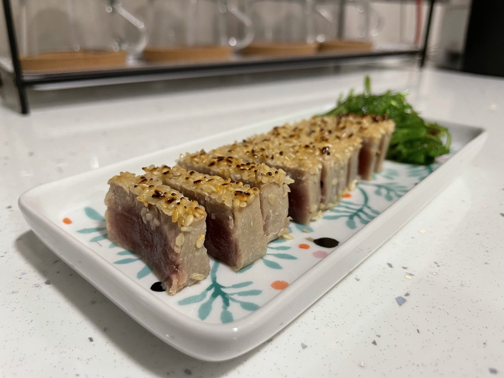 Plato de tataki de atún presentado con alga wakame